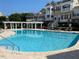 Inviting community pool surrounded by lounge seating and shaded pergola, perfect for relaxation at 10511 Sablewood Dr # 107, Raleigh, NC 27617