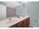 Bright bathroom featuring dual sinks with mirrors and a shower with a floral curtain at 1076 Kelso Ln, Burlington, NC 27215