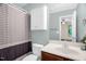 Well-lit bathroom featuring a vanity with modern faucet and a convenient shower with stylish striped curtain at 1076 Kelso Ln, Burlington, NC 27215