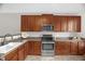 Functional kitchen featuring stainless steel appliances and wood cabinetry at 1076 Kelso Ln, Burlington, NC 27215