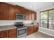 Cozy kitchen showcasing stainless steel appliances, wood cabinets, and natural light at 1076 Kelso Ln, Burlington, NC 27215