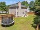Aerial view of fenced backyard with trampoline, patio seating and fire pit at 110 Bonhill Ct, Apex, NC 27502