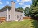 This backyard features a nice lawn, wooden fence, chimney, and patio with table set at 110 Bonhill Ct, Apex, NC 27502