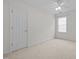 This bedroom features neutral carpet, a ceiling fan, and a window allowing for natural light at 110 Bonhill Ct, Apex, NC 27502