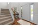 Bright entryway with wood floors, stairway, white door, and side window at 110 Bonhill Ct, Apex, NC 27502