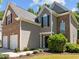 Exterior elevation featuring a two-car garage, brick and siding accents, and manicured landscaping at 110 Bonhill Ct, Apex, NC 27502