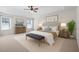 Bright main bedroom boasts a tray ceiling, neutral colors, bench, and ample natural light at 110 Bonhill Ct, Apex, NC 27502
