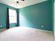 Bright bedroom featuring a large window with curtains, neutral carpet, and ample space at 1122 Birkdale Dr, Mebane, NC 27302
