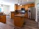 Spacious kitchen with stainless steel appliances, wooden cabinets, island, and hardwood floors at 1122 Birkdale Dr, Mebane, NC 27302
