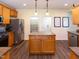 Well-equipped kitchen featuring stainless steel appliances, spacious island, wooden cabinets and hardwood floors at 1122 Birkdale Dr, Mebane, NC 27302