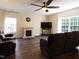 Comfortable living room featuring a fireplace, ceiling fan, large windows, and plush seating at 1122 Birkdale Dr, Mebane, NC 27302
