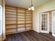 Office featuring built-in bookshelves, modern lighting, hardwood floors, and glass pane french doors at 1122 Birkdale Dr, Mebane, NC 27302
