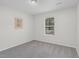 Simple bedroom with a large window offering natural light and neutral gray carpet at 1203 First Street Ext, Nashville, NC 27856