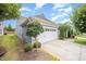 Home exterior showcasing a spacious two-car garage, lush landscaping, and a well-kept lawn at 1204 E Rosedale Creek Dr, Durham, NC 27703