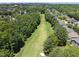 Aerial view of a golf course community, featuring lush green fairways and beautiful homes at 12257 Beestone Ln, Raleigh, NC 27614