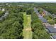 Aerial view of the house with a golf course in the backyard and surrounded by lush greenery and other houses at 12257 Beestone Ln, Raleigh, NC 27614