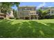 Expansive backyard view of a brick two-story home featuring a balcony and lush green lawn at 12257 Beestone Ln, Raleigh, NC 27614