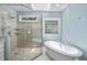 Bright bathroom with a glass shower, freestanding tub, and neutral tile at 12257 Beestone Ln, Raleigh, NC 27614