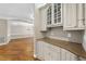 Butler's pantry featuring light-colored cabinets, granite countertop, and hardwood floors at 12257 Beestone Ln, Raleigh, NC 27614