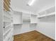 Organized walk-in closet with built-in shelving and hardwood floors at 12257 Beestone Ln, Raleigh, NC 27614