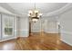 Spacious dining room with decorative chandelier, wood floors, and large window for natural light at 12257 Beestone Ln, Raleigh, NC 27614