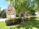 Brick house with a two-car garage, and well-maintained landscaping featuring trees and bushes at 12257 Beestone Ln, Raleigh, NC 27614
