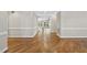 A bright hallway with hardwood floors, white trim and baseboards, and arched doorway views at 12257 Beestone Ln, Raleigh, NC 27614
