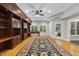 Home office featuring custom wooden shelving, desk area, ceiling fan, and a large rug at 12257 Beestone Ln, Raleigh, NC 27614