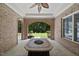 Outdoor patio featuring brick archways, ceiling fan, and a large stone table at 12257 Beestone Ln, Raleigh, NC 27614