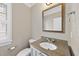 Elegant powder room with a granite vanity, bronze mirror, and neutral paint at 12257 Beestone Ln, Raleigh, NC 27614