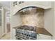Close up of the gas range with Jenn-Air hood in the kitchen at 12257 Beestone Ln, Raleigh, NC 27614