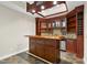 Custom wet bar featuring a mosaic backsplash, cabinetry, and stainless steel dishwasher at 12257 Beestone Ln, Raleigh, NC 27614