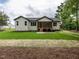 Home exterior with a screened-in porch, lush lawn, and landscaping at 1328 Bethlehem Church Rd, Youngsville, NC 27596