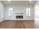 Inviting living room with wood-look floors, an electric fireplace, and a stylish white mantel at 1328 Bethlehem Church Rd, Youngsville, NC 27596