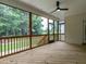 Inviting enclosed porch with wood floors, fan, and screens providing natural light and outdoor views at 1328 Bethlehem Church Rd, Youngsville, NC 27596
