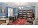 Elegant dining room with blue walls, hardwood floor and built-in bookshelves at 1413 Lily Creek Dr, Cary, NC 27518