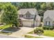 Aerial view of a two-story home with a three car garage and private backyard at 1413 Lily Creek Dr, Cary, NC 27518