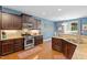 Bright kitchen with stainless steel appliances, granite counters, and hardwood floors at 1413 Lily Creek Dr, Cary, NC 27518
