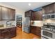 Spacious kitchen featuring stainless steel appliances, granite countertops, and dark wood cabinets at 1413 Lily Creek Dr, Cary, NC 27518
