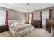 Main bedroom featuring tray ceilings, carpet, a fan, and windows at 1413 Lily Creek Dr, Cary, NC 27518