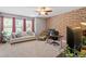 Bright office with a brick accent wall, couch, and large windows at 1413 Lily Creek Dr, Cary, NC 27518