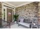 Inviting front porch with stone wall, bench, potted plant, and charming decor at 1413 Lily Creek Dr, Cary, NC 27518