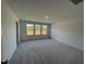 The bedroom has three large windows that let in plenty of natural light and gray carpet at 154 N Finley Landing Pkwy, Smithfield, NC 27577