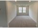 Neutral bedroom with plush carpeting, recessed lighting, and natural light streaming in through two windows at 154 N Finley Landing Pkwy, Smithfield, NC 27577