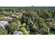 Aerial view shows houses surrounded by mature trees with a distant city skyline against a clear sky at 1811 Ridley St, Raleigh, NC 27608