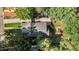 Directly above a house and yard with mature trees and a play structure on a bright day at 1811 Ridley St, Raleigh, NC 27608
