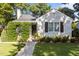 Charming cottage-style home with lush landscaping and a walkway leading to the front door at 1811 Ridley St, Raleigh, NC 27608