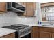 Close-up of kitchen featuring stainless steel appliances, white tile backsplash, and wooden cabinets at 1811 Ridley St, Raleigh, NC 27608