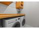 Modern laundry room with wood countertop, overhead cabinets, and white washer/dryer at 1811 Ridley St, Raleigh, NC 27608
