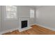 Living room featuring a white fireplace and hardwood floors with windows for natural light at 1811 Ridley St, Raleigh, NC 27608